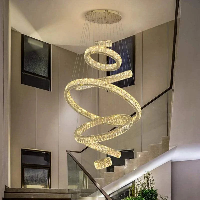 Elegant hall chandelier with spiral LED rings hanging above staircase in modern interior