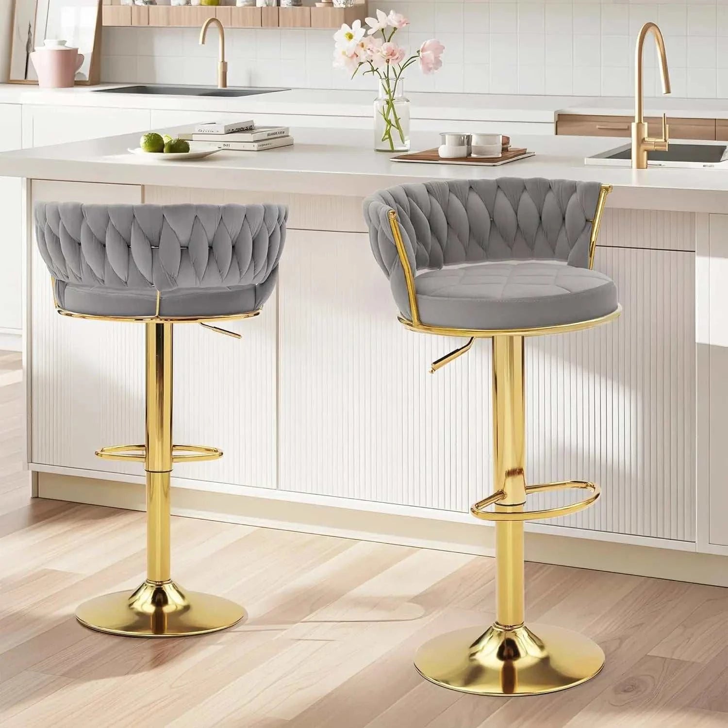 Set of 2 velvet adjustable bar stools with gold metal base, swivel seat, woven back, and footrests in modern kitchen setting