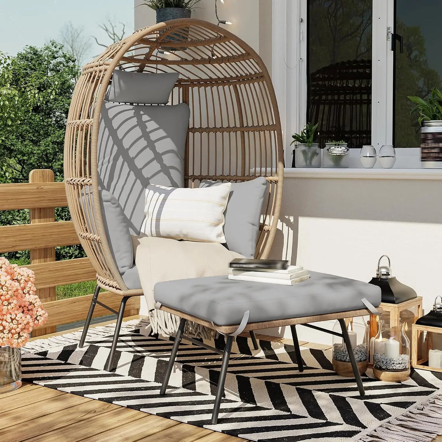 Wicker chair with cushions on a patio with a striped rug and outdoor decor.