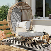 Wicker chair with cushions on a patio with a striped rug and outdoor decor.