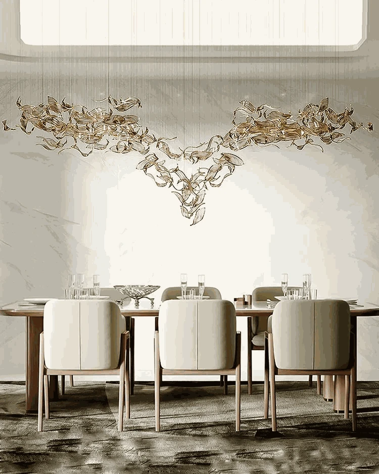 Modern dining room with a large chandelier and marble walls.