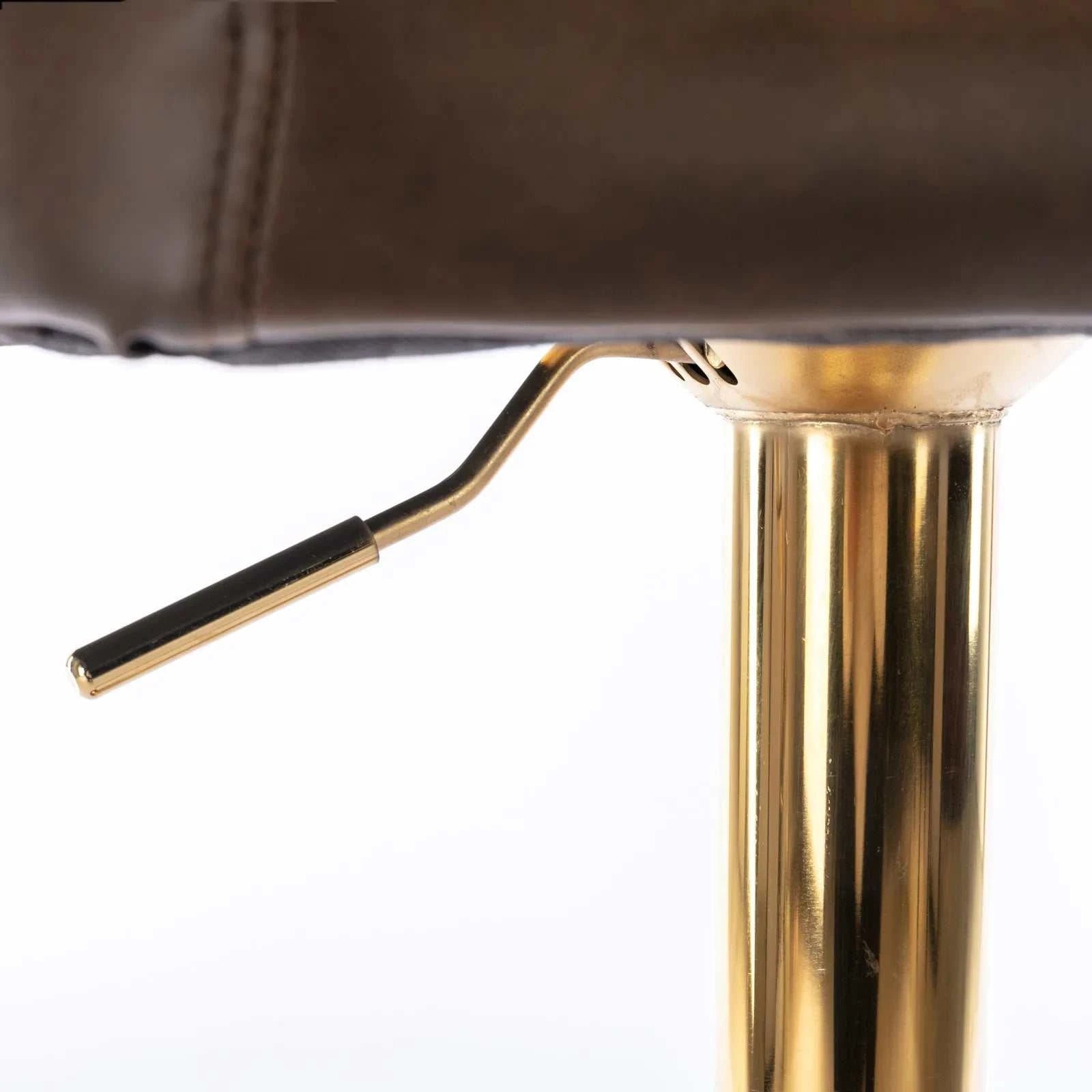 Close-up of a brown leather chair with a gold metal leg on a white background