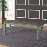 Wooden bench with teal legs in a room with a gray wall and large window.