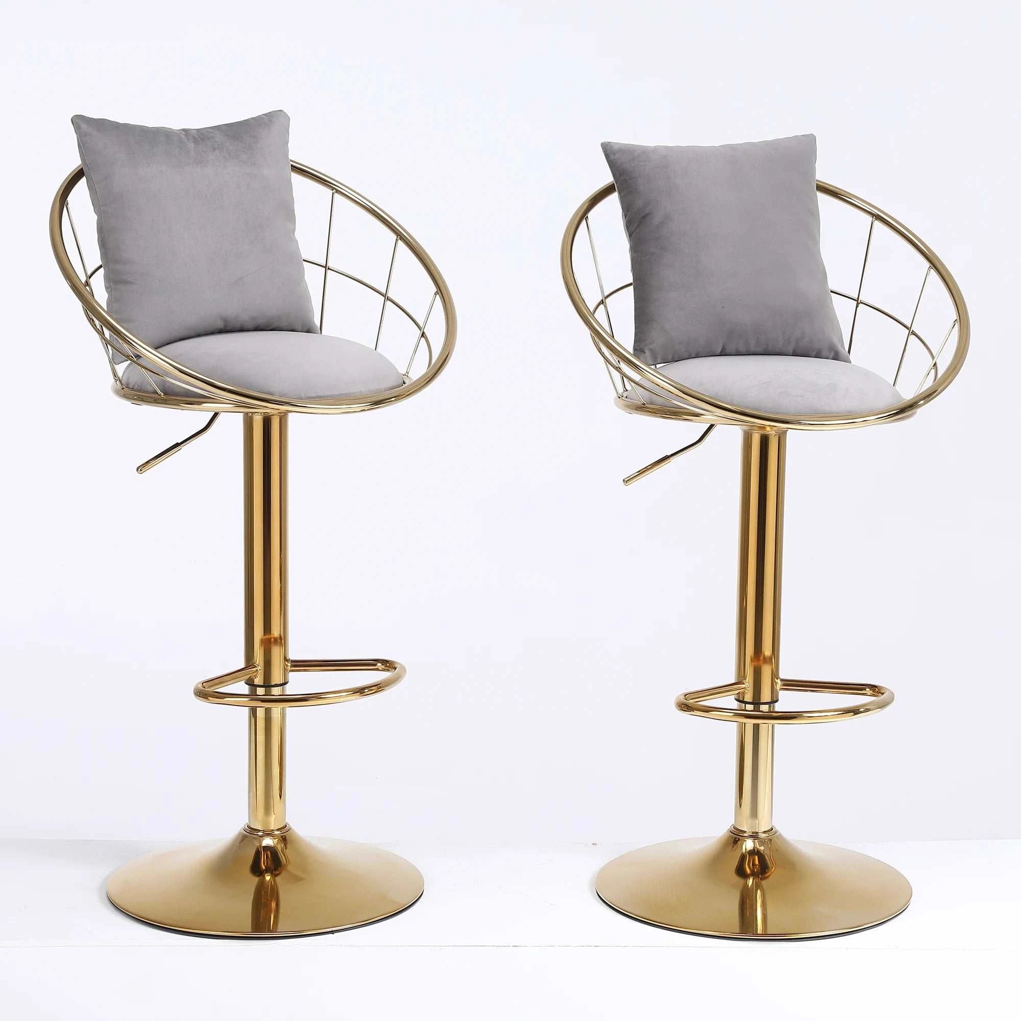 Two gold bar stools with gray cushions on a white background