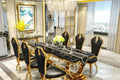 Dining table set with black chairs and gold accents in a modern room.