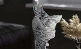 Glass sculpture of a fish on a dark background