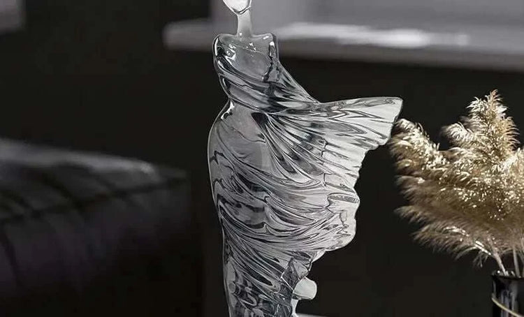 Glass sculpture of a fish on a dark background
