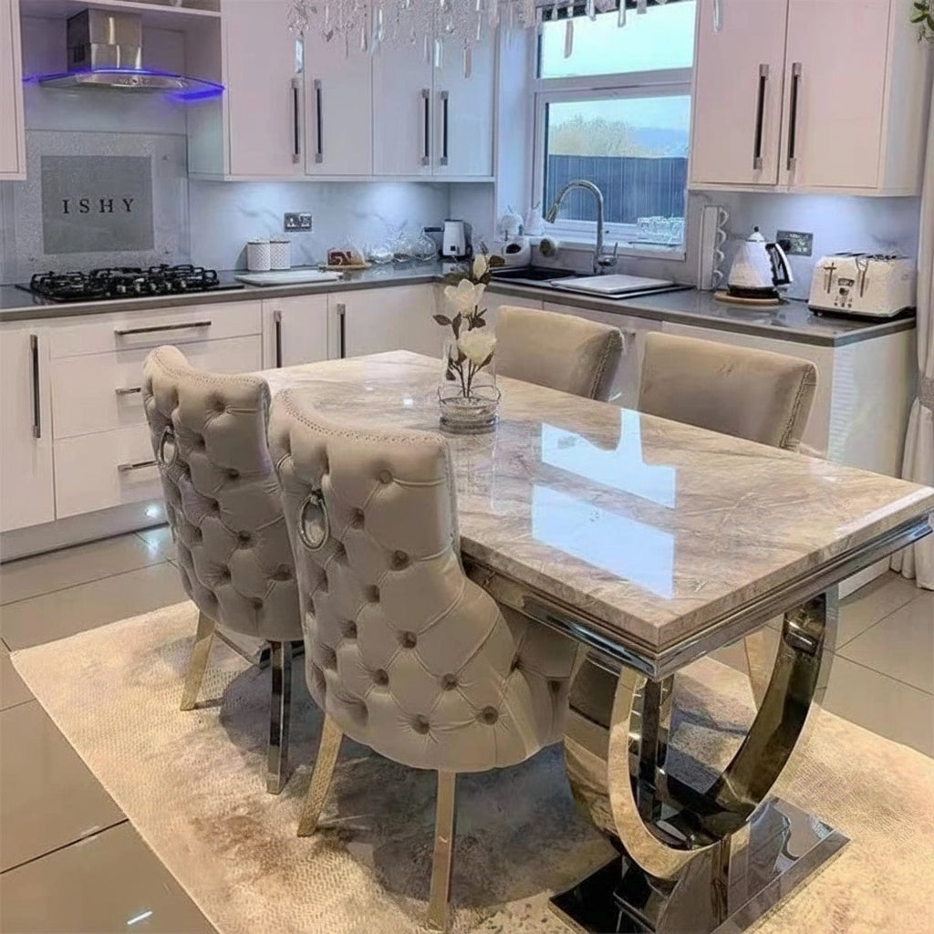 Luxury marble dining table set with designer silver frame and tufted chairs in a modern kitchen.