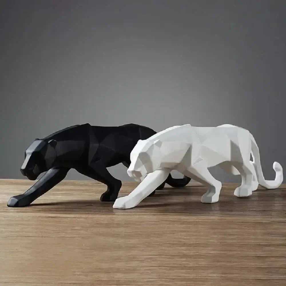 Black and white geometric panther sculptures on a wooden surface with a dark gray background