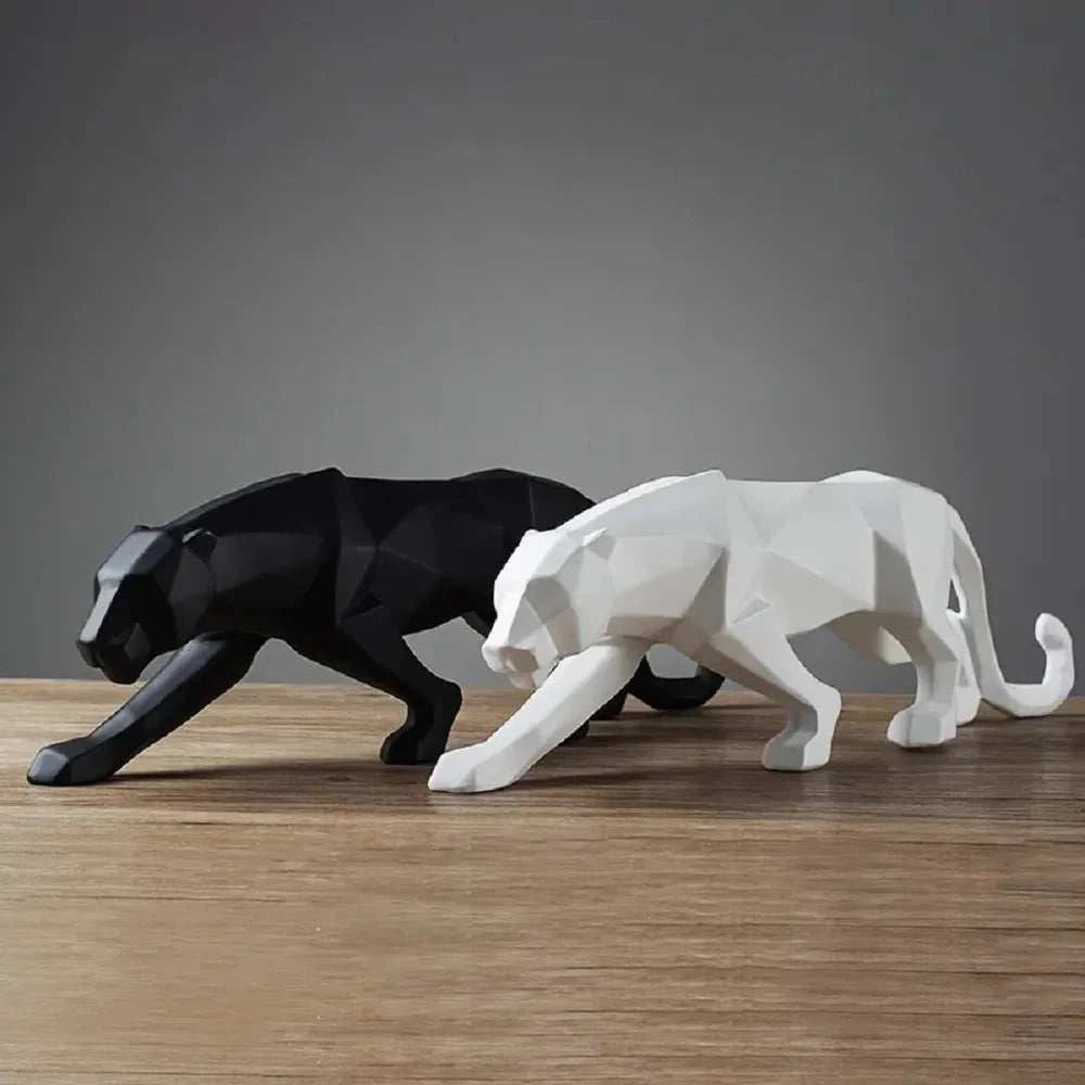 Black and white geometric panther sculptures on a wooden surface with a dark gray background