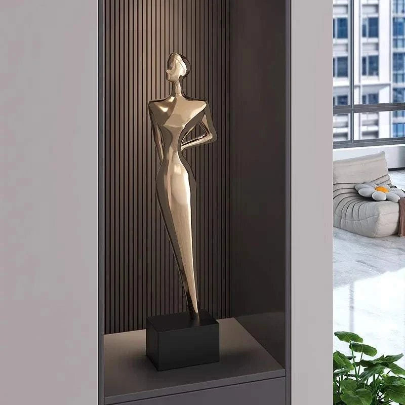 Gold abstract sculpture on a black base in a modern interior setting