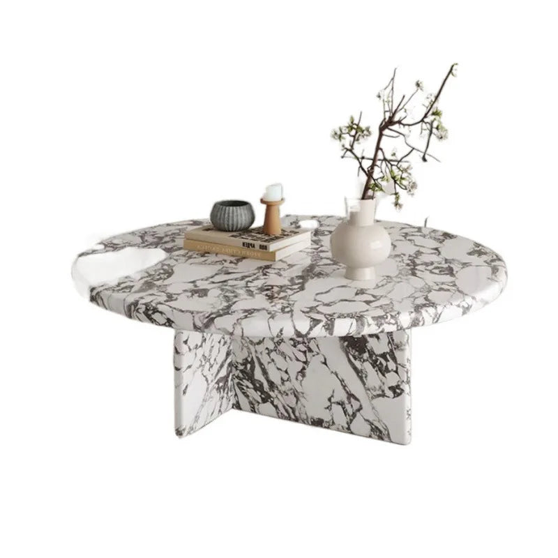 Marble-patterned coffee table with decorative items on a white background