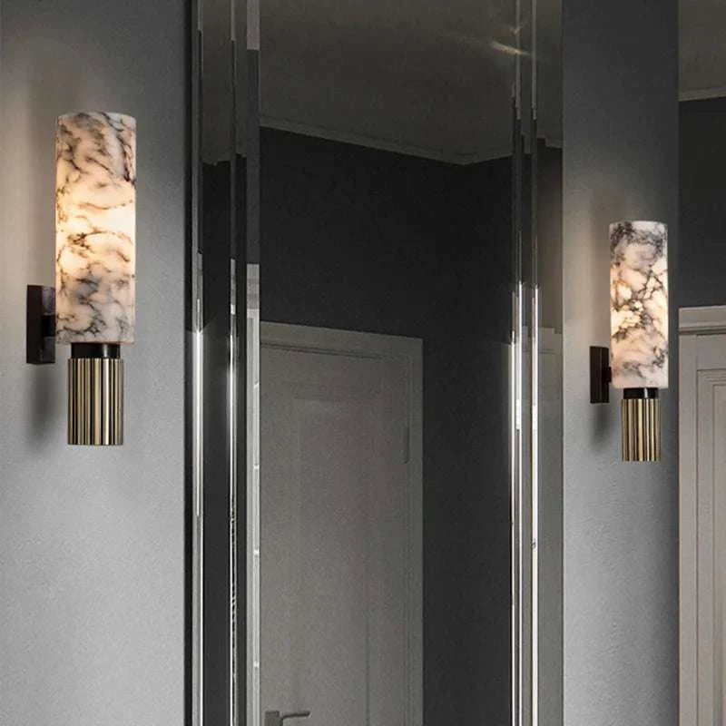 Pair of wall sconces with marble-like finish on a gray wall.