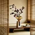 Vintage luxury glass vase with decorative branches in a serene interior setting.