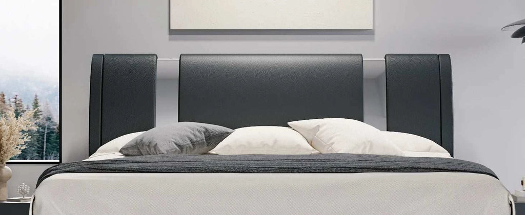 Modern bed with black headboard and gray bedding in a room setting.