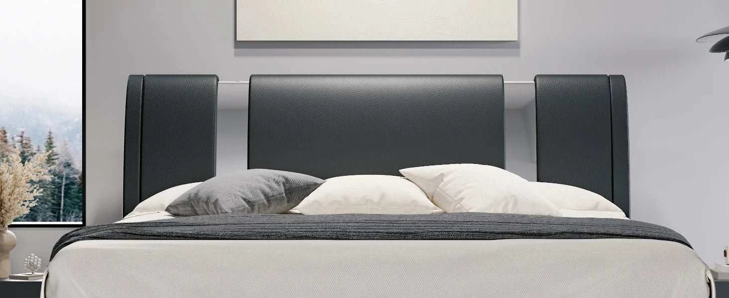 Modern bed with black headboard and gray bedding in a room setting.