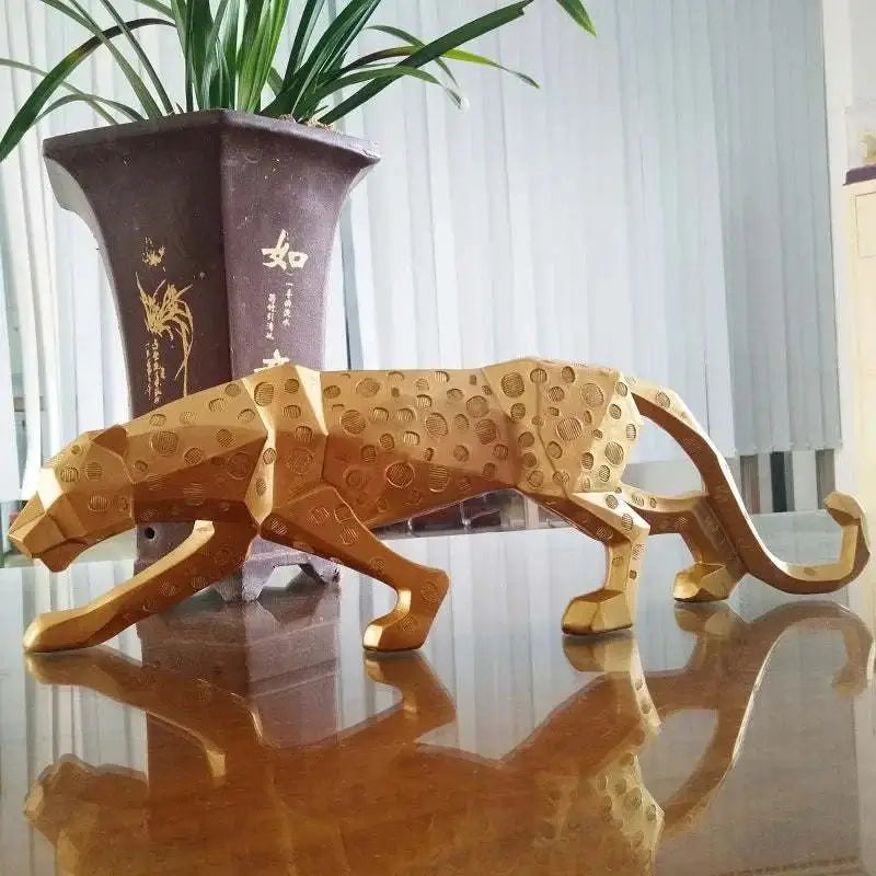 Abstract geometric panther sculpture elegantly displayed on a table next to a decorative plant.