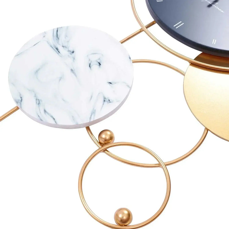 Close-up view of large gold metal wall clock showcasing modern design with marble and gold accents.