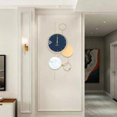 Large Gold Metal Wall Clock displayed on a wall, featuring a modern design with various circular elements.