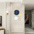 Large Gold Metal Wall Clock displayed on a wall, featuring a modern design with various circular elements.