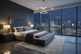 Modern upholstered king size bed with tufted headboard in a contemporary bedroom with city view.