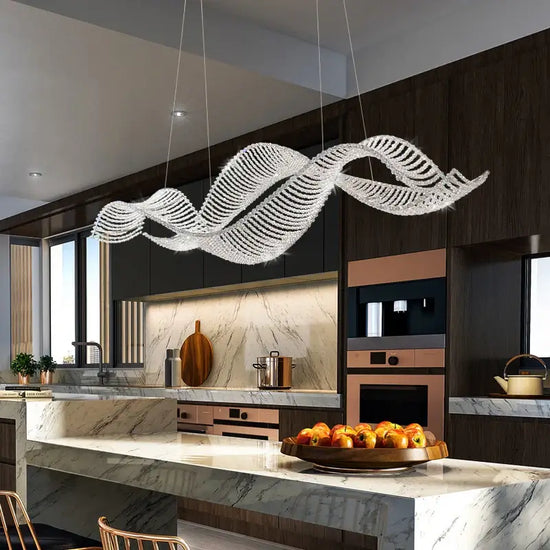 modern French crystal chandelier in a stylish kitchen over a marble island table.