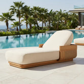 Solid Teak Wood Outdoor Sun Lounger Chaise by the poolside with lush greenery in the background.