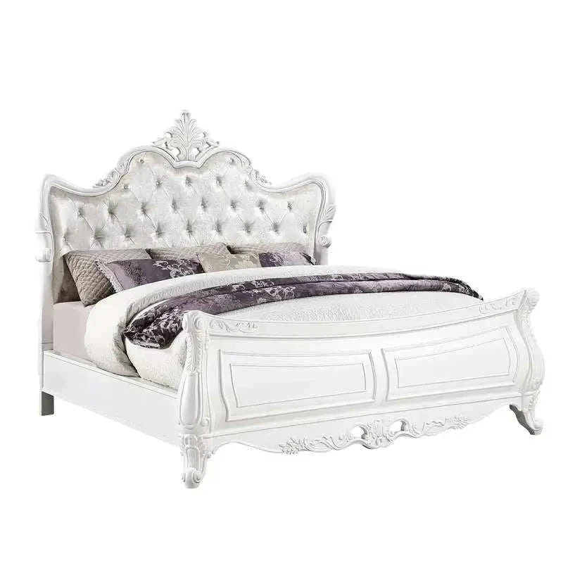 White ornate bed with decorative headboard and bedding on a white background