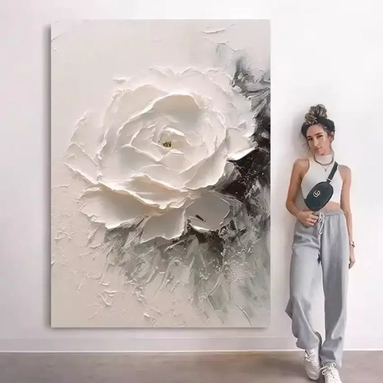 Woman standing next to a large abstract painting of a white flower
