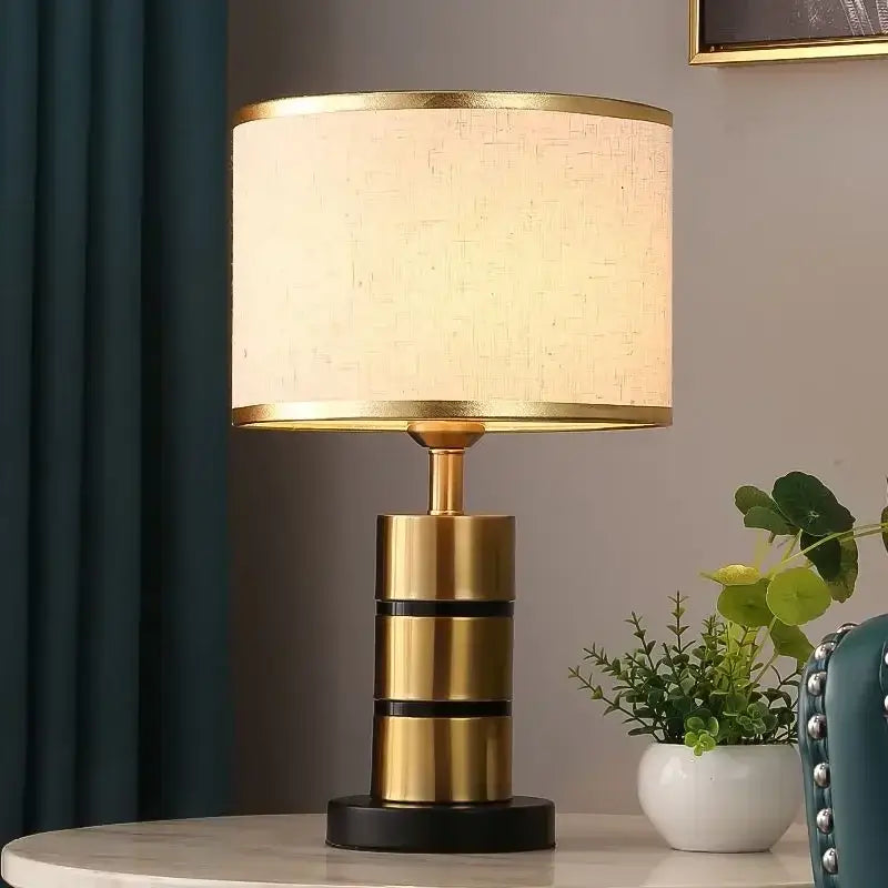Luxury LED bedside lamp with a gold frame and fabric shade, providing warm light for modern decor.