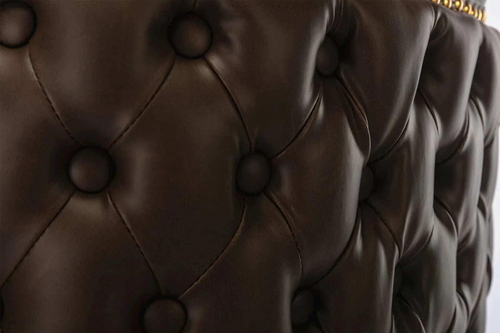 Close-up of a brown leather headboard with tufted design