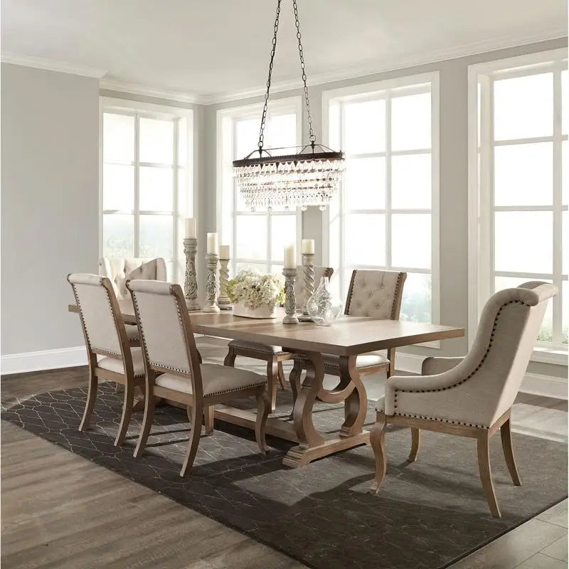 Dining room with wooden table and upholstered chairs in a well-lit room.