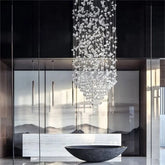 Modern interior with a crystal chandelier hanging above a reflective surface.