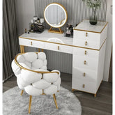 White vanity table with gold accents and a matching chair in a room setting.