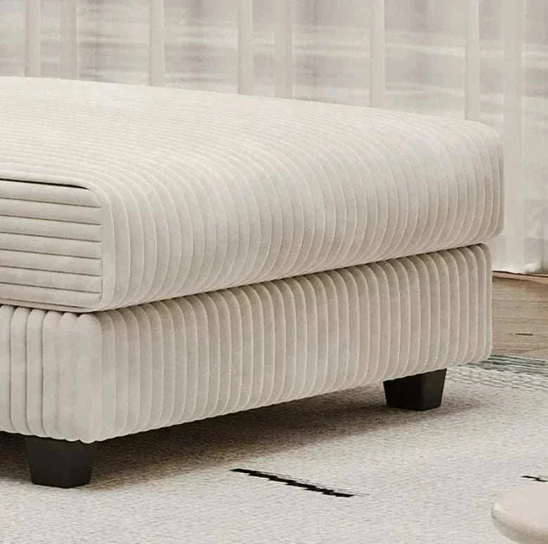Beige textured ottoman with black legs on a light gray carpet