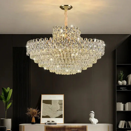 Luxurious chandelier hanging in a room with a dark wall and decorative items.