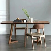 Wooden dining table with chairs against a gray wall