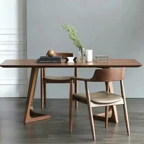 Wooden dining table with chairs against a gray wall