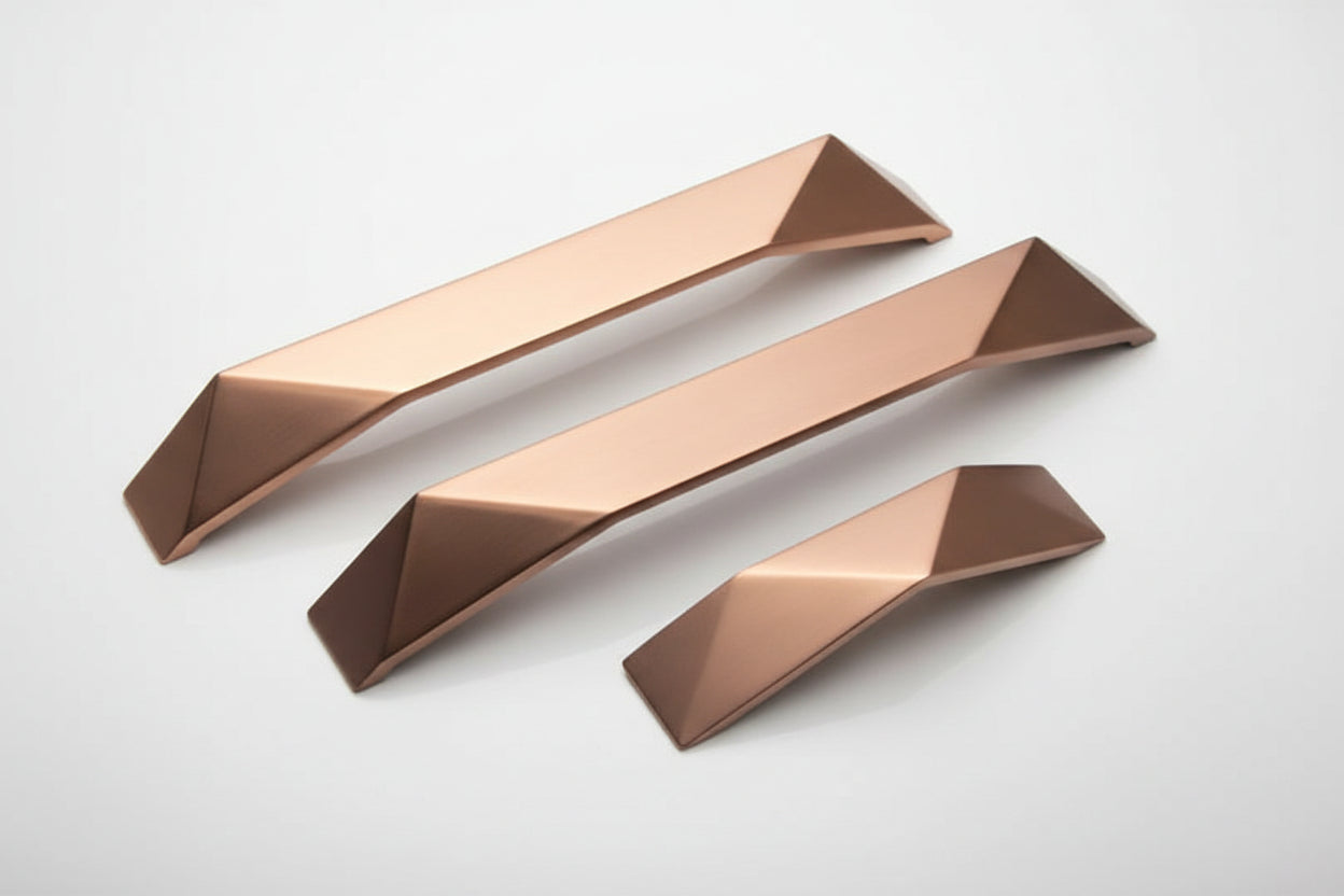 Four metallic copper-colored knife blade guides or sharpening steel accessories arranged diagonally on a plain white background.