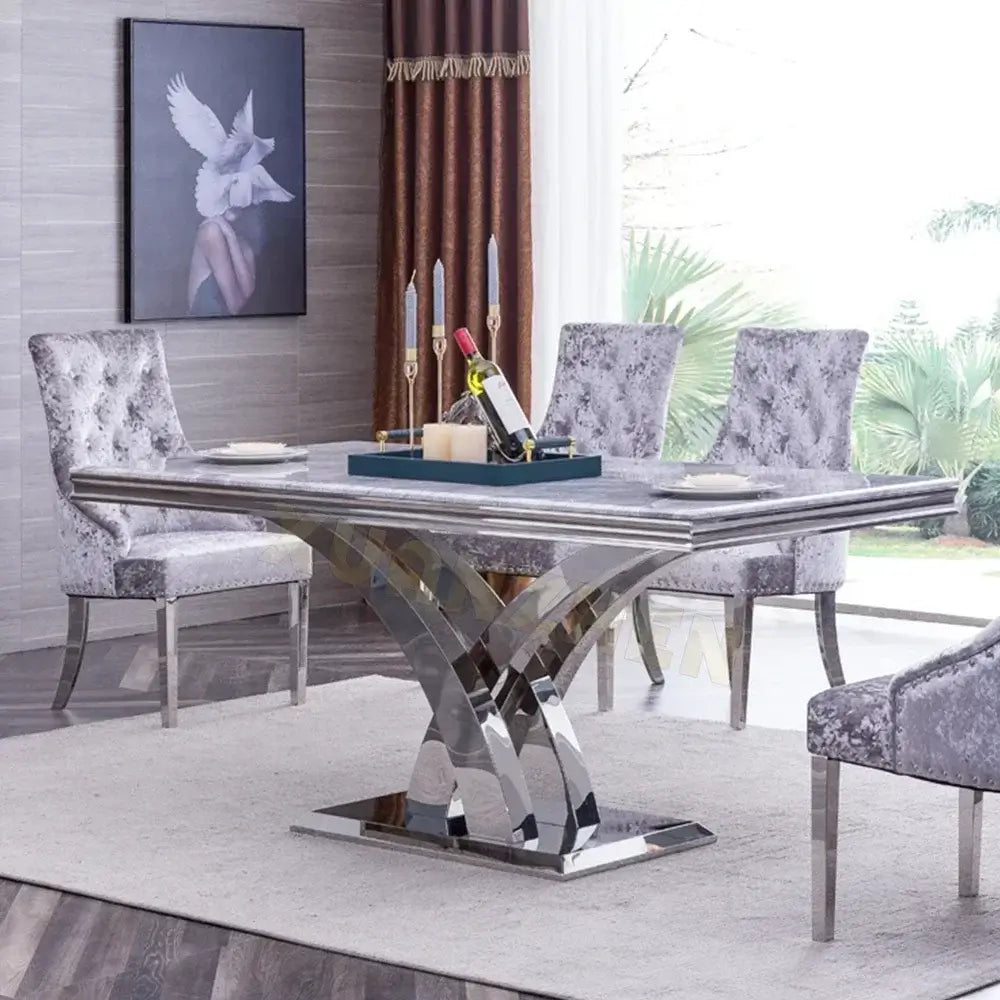 Dining room with a modern stainless steel table and gray chairs.