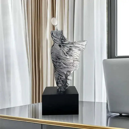 Decorative glass sculpture on a black base in a modern interior setting