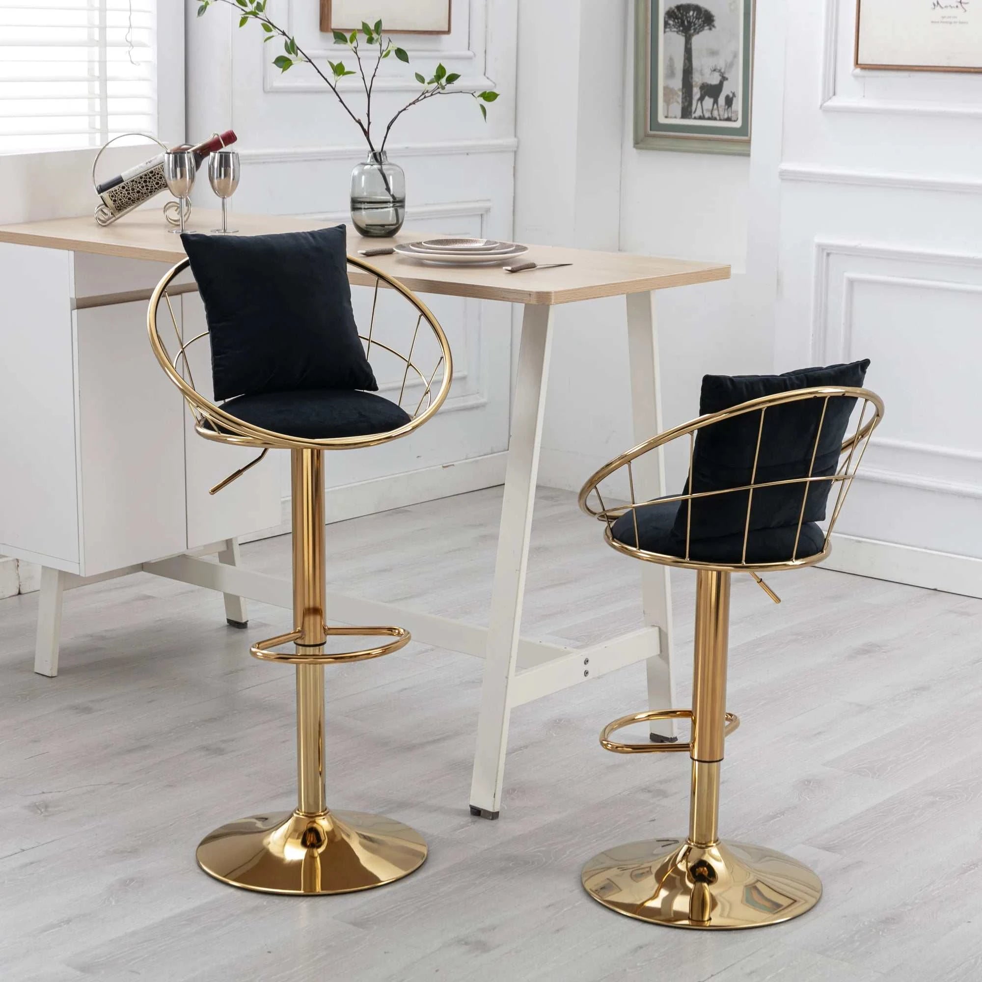 Two gold bar stools with black cushions in a room with a table and decor.