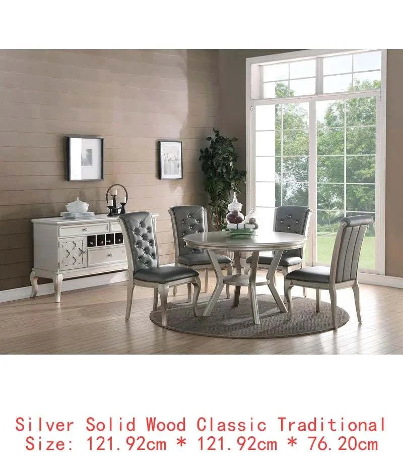 Dining room set with a round table and 4 chairs in a well-lit room.