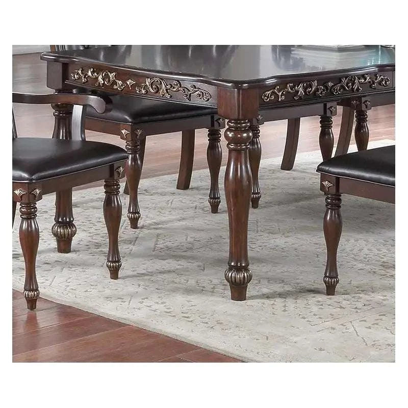 Dining table with ornate carvings on a wooden floor