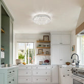 Modern kitchen with white cabinets, a ceiling light fixture, and a window view.