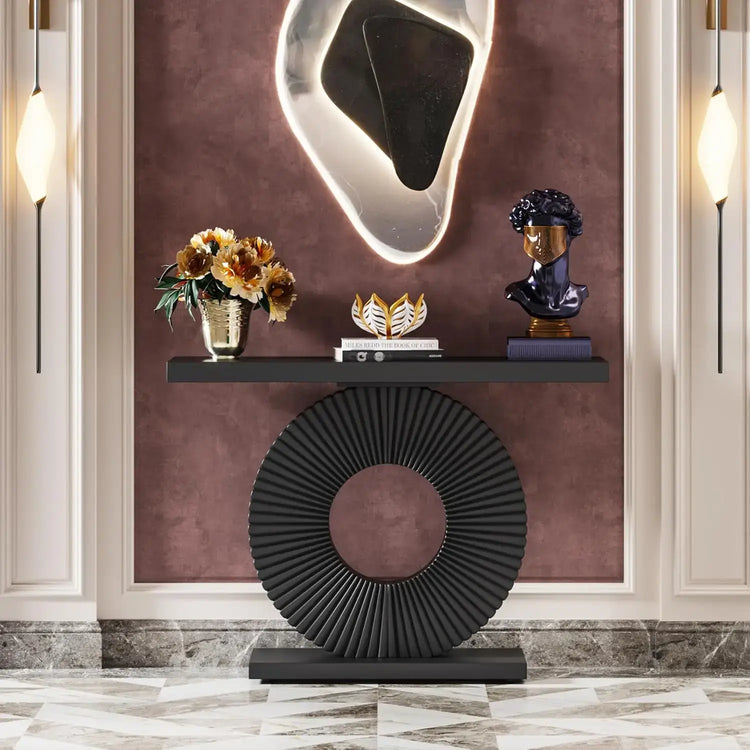 Decorative console table with a round base and shelf against a wall with a textured finish.