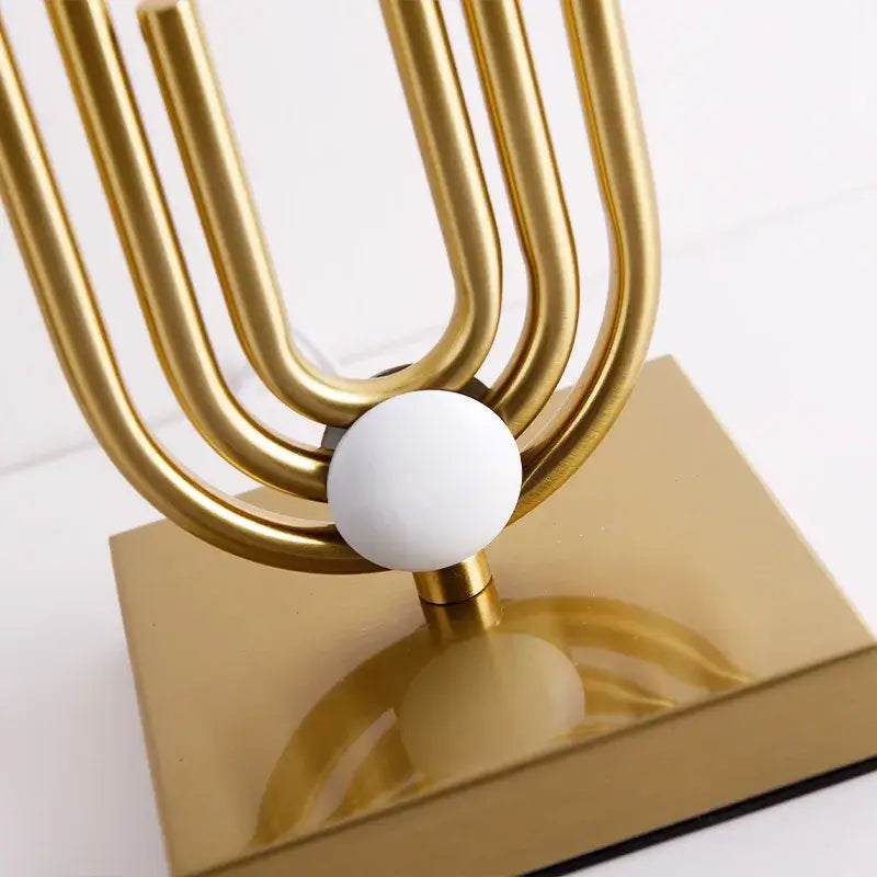 Nordic luxury bedside lamp design with gold metal frame and white spherical accent.