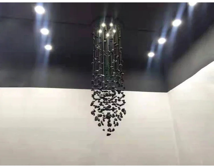 Modern chandelier hanging from a ceiling with lights on