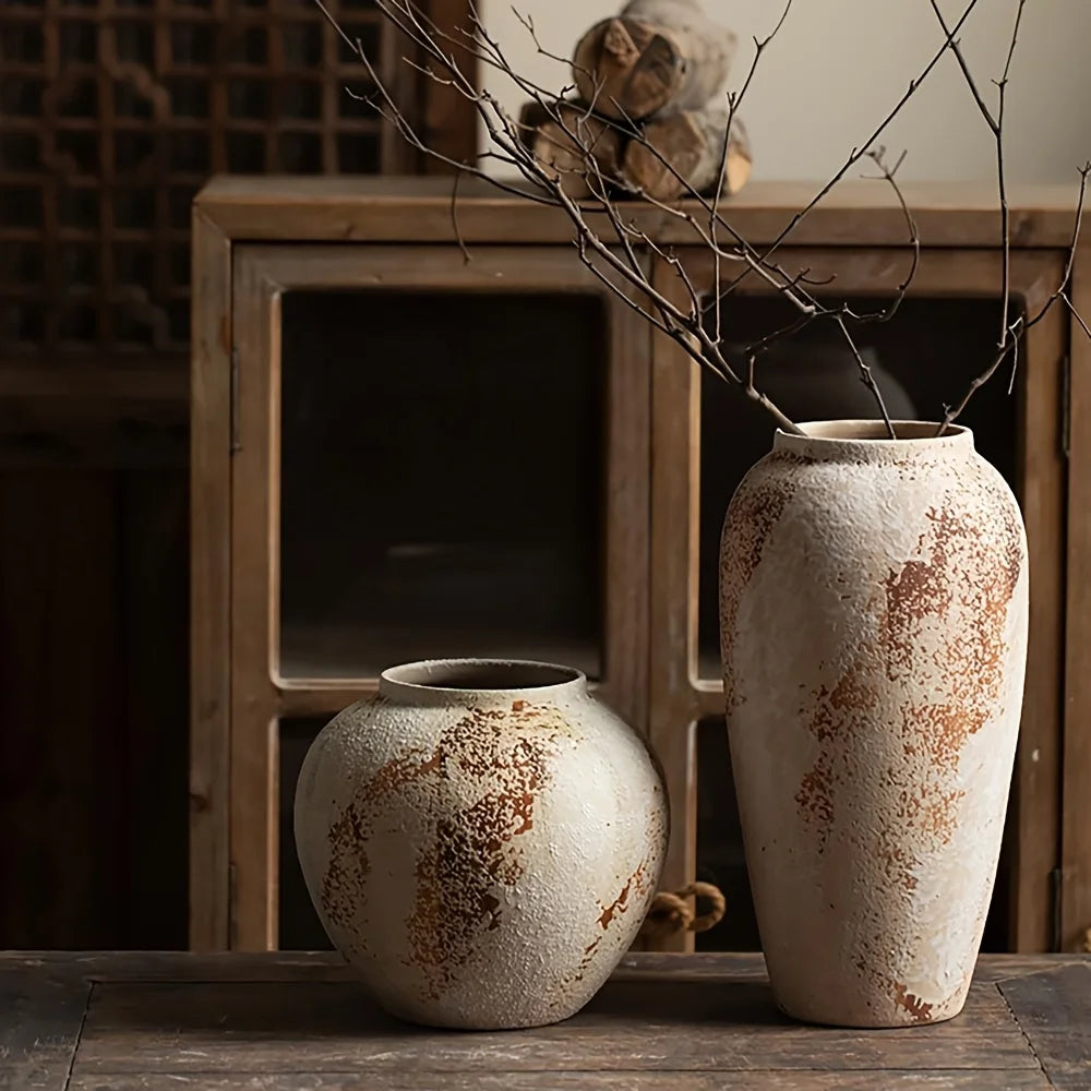 Two rustic ceramic vases on a wooden surface with a blurred background