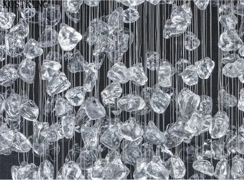 Crystal-like shapes hanging vertically against a black background